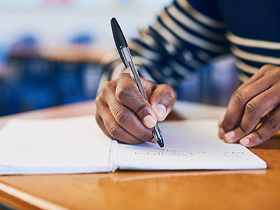 student writing at desk