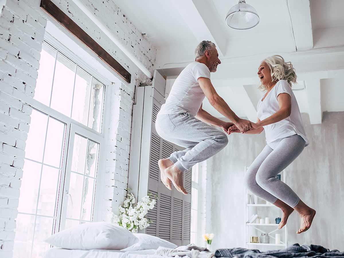 couple jumping on bed